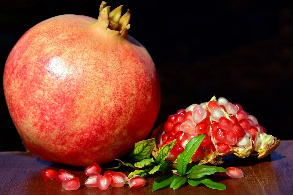 Pomegranate cut in half revealing its red seeds, an antioxidant-rich fruit associated with vitamin C