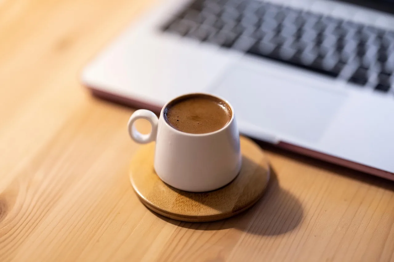 Tasse de café près d'un ordinateur portable au travail – la fatigue, motif fréquent de la carence en fer chez les femmes en âge de procréer