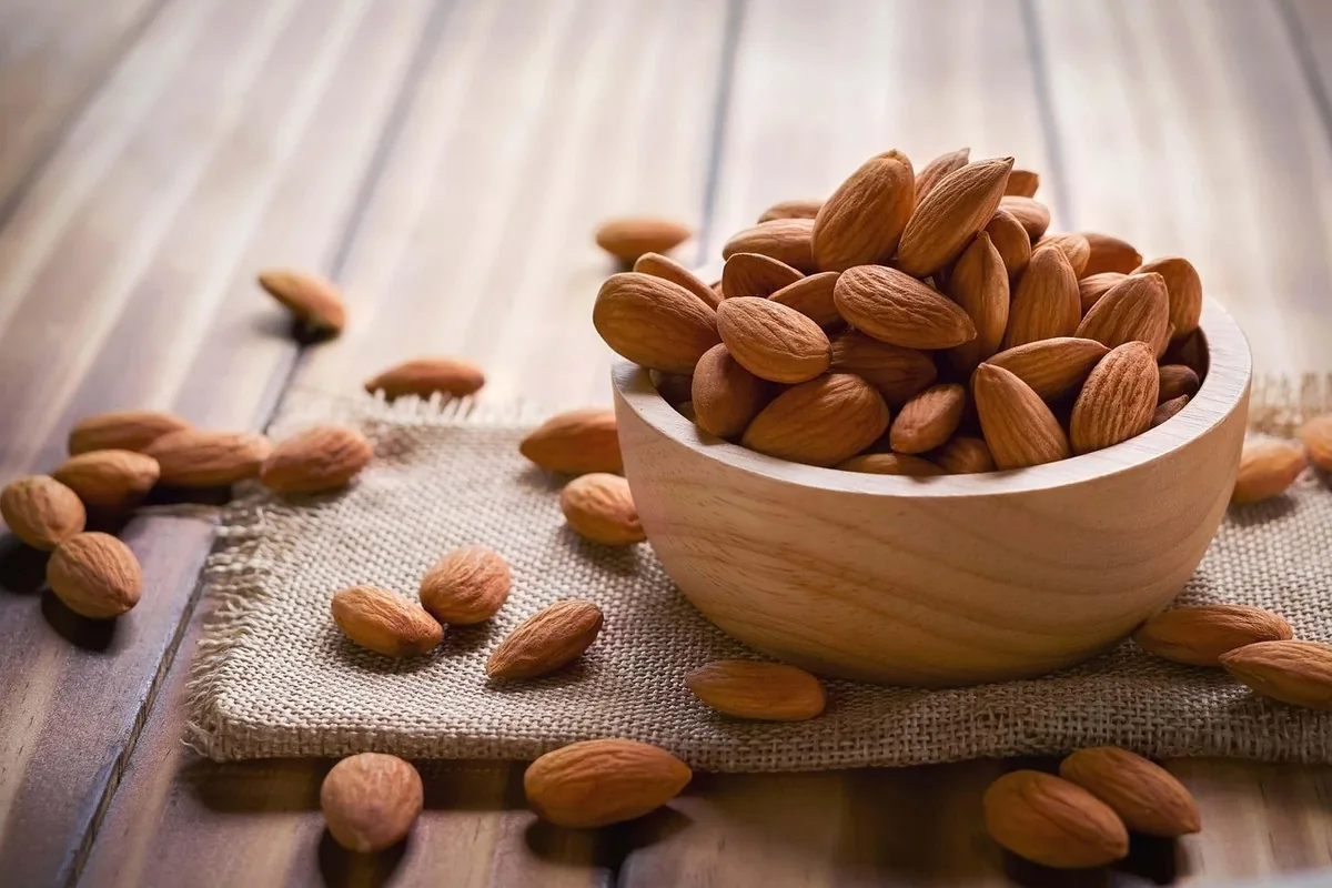 Prendre du poids naturellement quand on est trop maigre 13 Fruits secs, amandes, noix et huile d'olive disposés sur une table, exemples d'aliments denses en calories de qualité pour la prise de poids